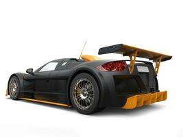 Awesome supercar in matte black paint with yellow details - back view photo