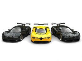 Beautiful yellow super car with two black sports cars on each side photo