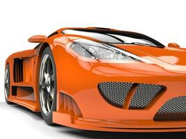 Tangerine orange modern super sports car - headlight extreme closeup shot photo