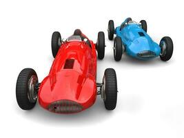 Red and blue vintage sport cars in a race, red leading photo