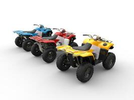 Quad bikes in primary colors - red, blue and yellow - back side view photo