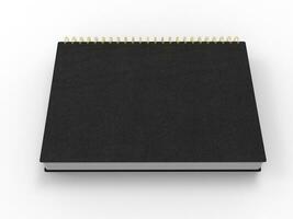 Black notebook with golden spiral binding and leather covers - top down side view photo