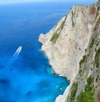 Aerial view cliffside aand the boat rushing by photo