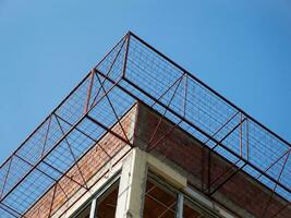 Metal wire cage on the unfinished building facade photo