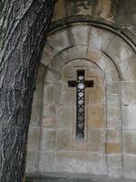 Small old church cross window - old tree in the foreground photo