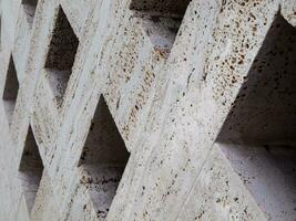 Square holes on stone wall - texture photo