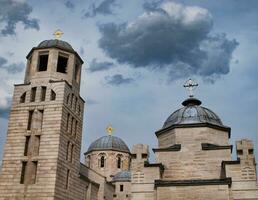 Beige stone church with gold and silver crosses photo