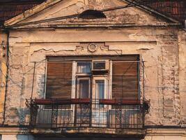 ornamental balcón en un antiguo correr abajo casa foto