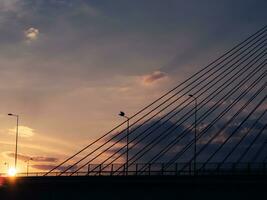 puesta de sol terminado el grande suspensión puente y autopista foto