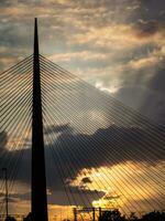 grande torre suspensión puente silueta a puesta de sol foto