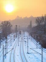 Train tracks in winter time near industrial part of the city photo