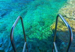 Beautiful clear blue waters of Aegean Sea - edge of the rail steps on the ship photo