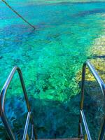 Beautiful clear blue waters of Aegean Sea - edge of the rail steps on the ship photo