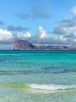 Amazing clear blue water on Balos beach - Gramvousa fortress on the horizon photo