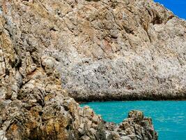 Dry rocks and perfectly blue sea photo