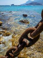 grande oxidado Embarcacion cadena, cristal claro agua en el antecedentes foto