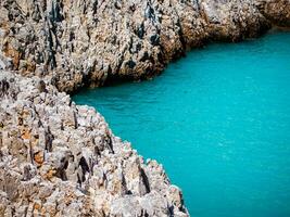 blanco rocoso bordes y increíble azul mar agua foto