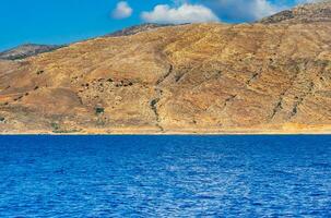 Orange rocky hill and deep blue ocean photo