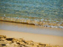 Small waves on a nice empty sandy beach - crystal clear water photo