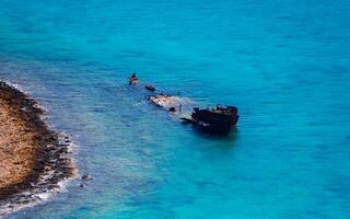 Sunken ship in the shallow blue water photo