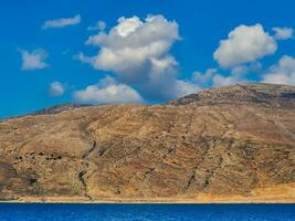 Orange rocky hills and beautiful blue sea and sky photo