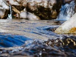 Water waves in cold mountain creek - extreme closeup shot photo