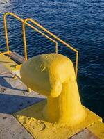 Bright yellow dock tie and yellow stairs on the pier photo