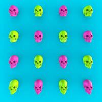 Mad green and ping skulls on bright blue background photo