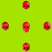 Red skulls on bright green background photo