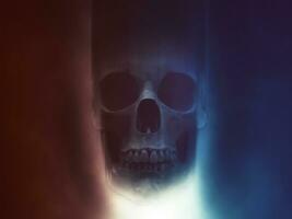 Skull in red and blue smoke with light shining from below photo