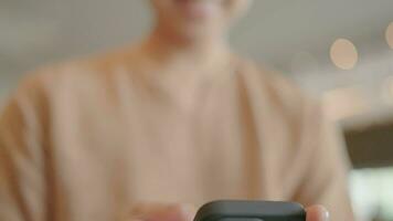 Close-up of a happy man sitting typing a message on his smartphone in a chat app. video