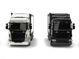 Black and white modern heavy transport trucks - front view photo