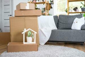 cajas con cosas para Moviente y casa plantas son en el habitación de el nuevo casa. estreno de una casa, familia propiedad, carga transporte y entrega de cosas foto