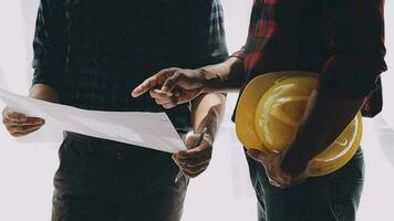 Image of team engineer checks construction blueprints on new project with engineering tools at desk in office. video