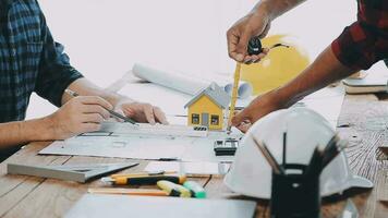 Image of team engineer checks construction blueprints on new project with engineering tools at desk in office. video