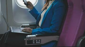 erfolgreich schön jung asiatisch Geschäft Frau sitzt im Flugzeug Kabinenflugzeug und funktioniert auf Digital Tablette mit Stift. fliegend beim zuerst Klasse. video