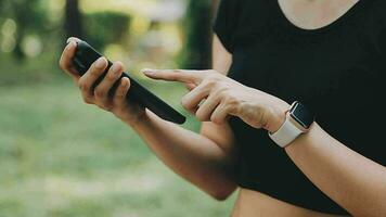 le athlète montres cardio, aptitude dans le ville. une femme regards à des sports et compte calories pendant entraînement. exercice entraîneur sur le rue, en bonne santé mode de vie. video