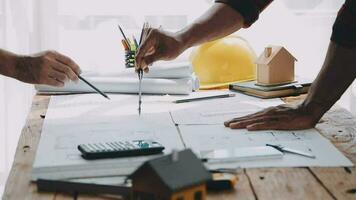 Image of team engineer checks construction blueprints on new project with engineering tools at desk in office. video