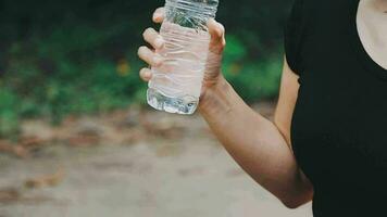 Bebiendo agua, aptitud y ejercicio mujer después Deportes correr y formación en naturaleza. ejercicio, excursionismo y caminando desafío con un botella de un hembra corredor en verano Listo para corriendo para salud video