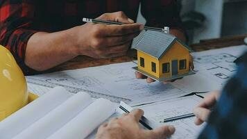 Image of team engineer checks construction blueprints on new project with engineering tools at desk in office. video