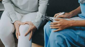 Doctor and patient sitting and talking at medical examination at hospital office, close-up. Therapist filling up medication history records. Medicine and healthcare concept. video