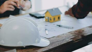 Image of team engineer checks construction blueprints on new project with engineering tools at desk in office. video