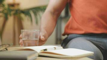 Freelancer drinking water sitting at table video