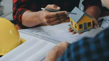 Image of team engineer checks construction blueprints on new project with engineering tools at desk in office. video