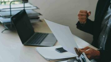 atraente o negócio ásia homem trabalhando com computador computador portátil em de madeira mesa às lar. analisando conectados dados para sucesso o negócio video