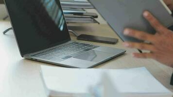 attractive business asian man working with computer laptop on wooden table at home. analyzing online data to success business video