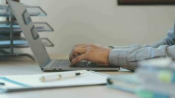 attractive business asian man working with computer laptop on wooden table at home. analyzing online data to success business video