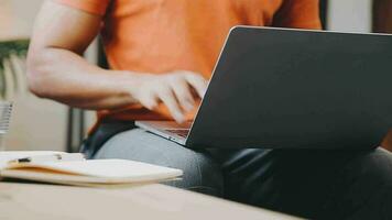 Junger Geschäftsmann, der zu Hause mit Laptop und Papieren auf dem Schreibtisch arbeitet video