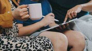 Children sister and brother playing drawing together on floor while young parents relaxing at home on sofa, little boy girl having fun, friendship between siblings, family leisure time in living room video