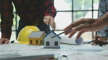 Team of multiethnic architects working on construction plans in meeting room. Engineers discussing on project in office. Mature businessman and woman standing around table working on blueprint. video